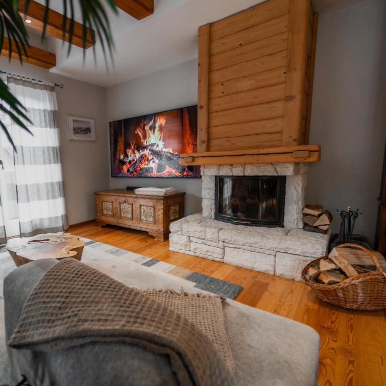 a living room with a fireplace and a couch at CHALET MACESEN Apartment Mauro with sauna - in the center of Kranjska gora in Kranjska Gora