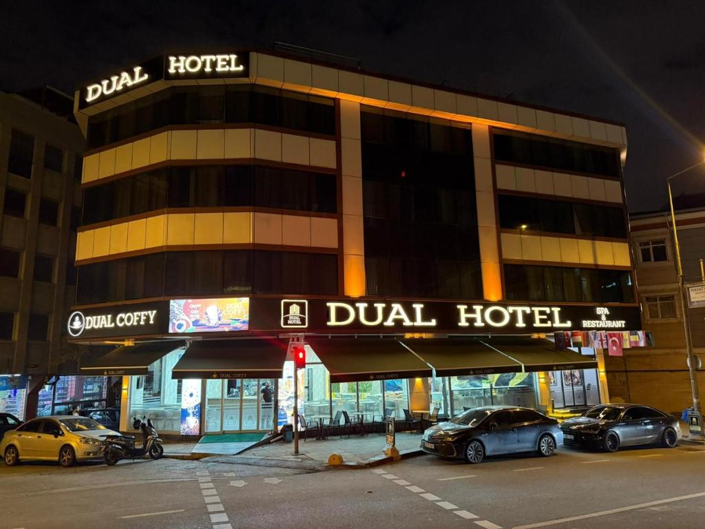 a hotel with cars parked in a parking lot at Dual Hotel Halkalı in Istanbul