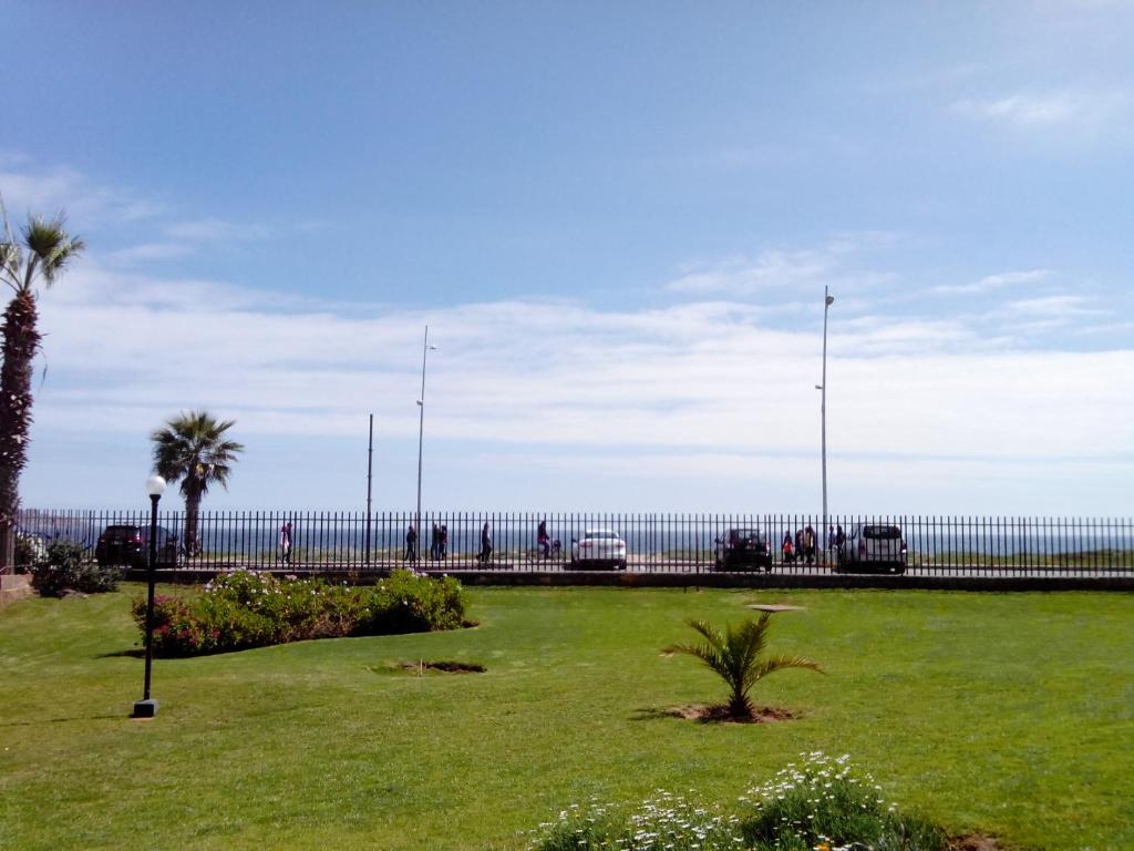 un parque con palmeras y el océano al fondo en Departamento La Serena 104, en La Serena