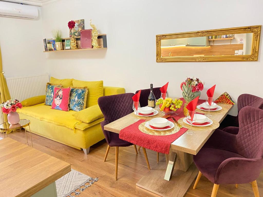 a living room with a table and a yellow couch at Deluxe Suite in Vienna
