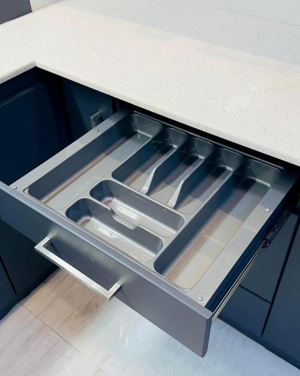 an empty drawer in a kitchen with some utensils at Bella Home in Sohāna