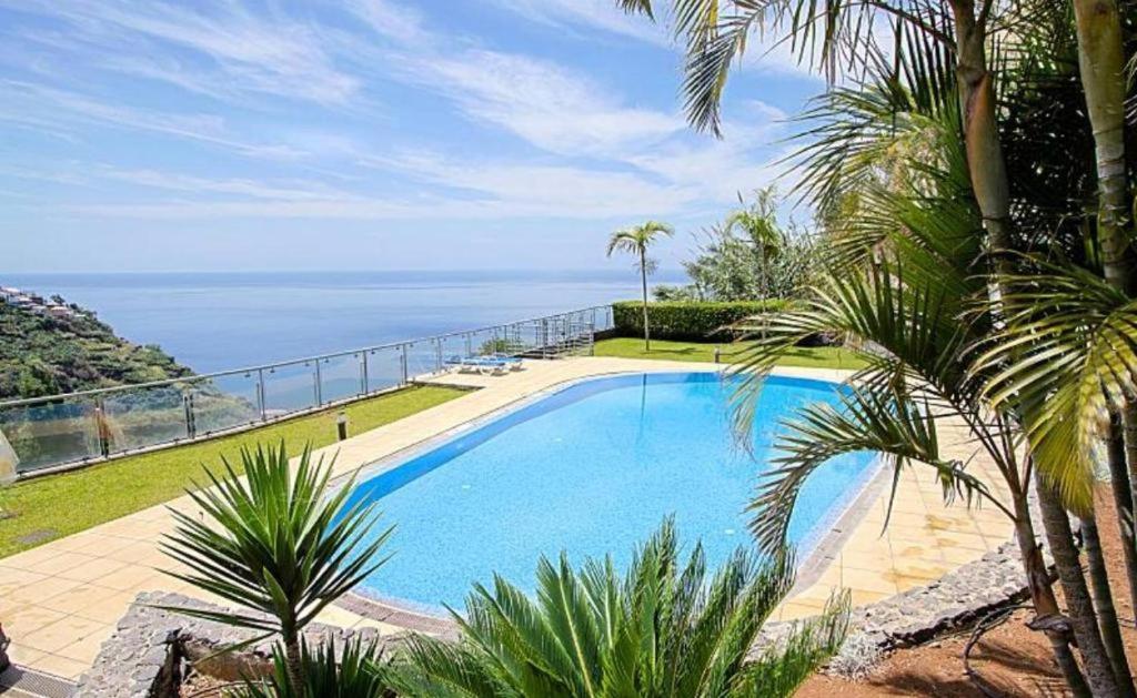 a swimming pool with a view of the ocean at Vista Calheta Apartment in Calheta