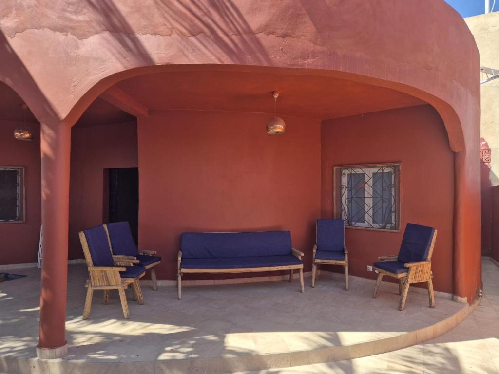 a group of chairs and tables in a patio at Chambre climatisée balcon in Fatick