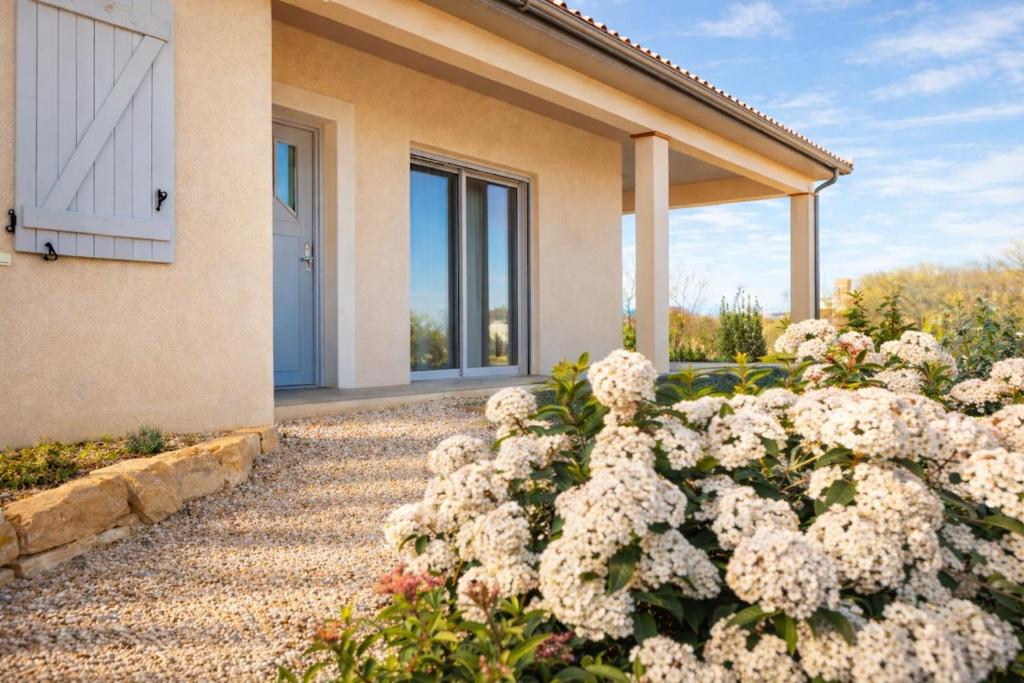 a garden of white flowers in front of a house at Gite Lagarrigue in Lavaur