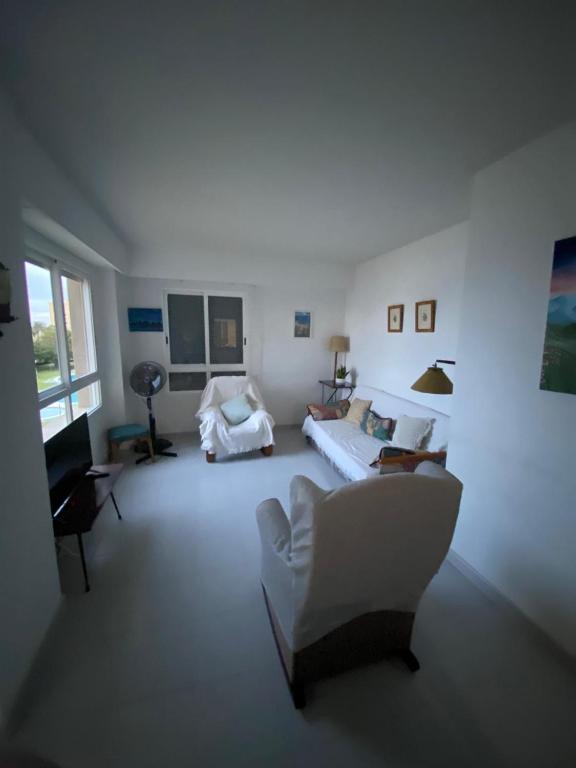 a white living room with a couch and a chair at Urbanova apartamento in El Alted