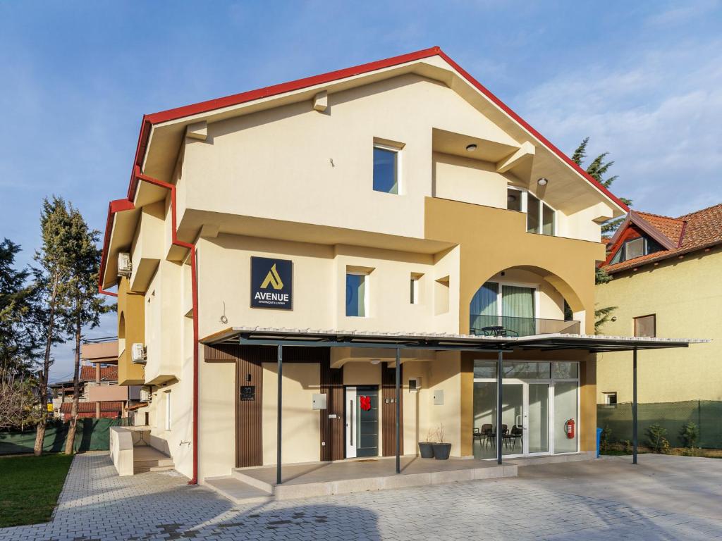 a building with a sign on the front of it at Avenue Apartments Ilinden in Ilinden