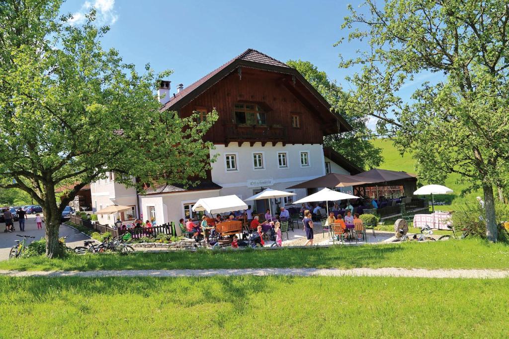 a group of people sitting at tables in front of a building at Erlachmühle in Mondsee