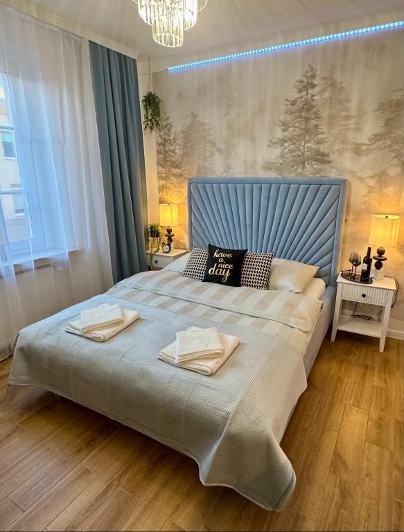 a bedroom with a large bed with two towels on it at Dan Apartament C, Self check-in in Opole