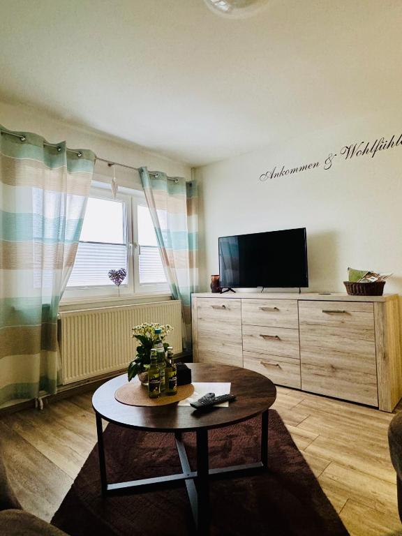 a living room with a coffee table and a tv at Harz Flair Schierke in Schierke