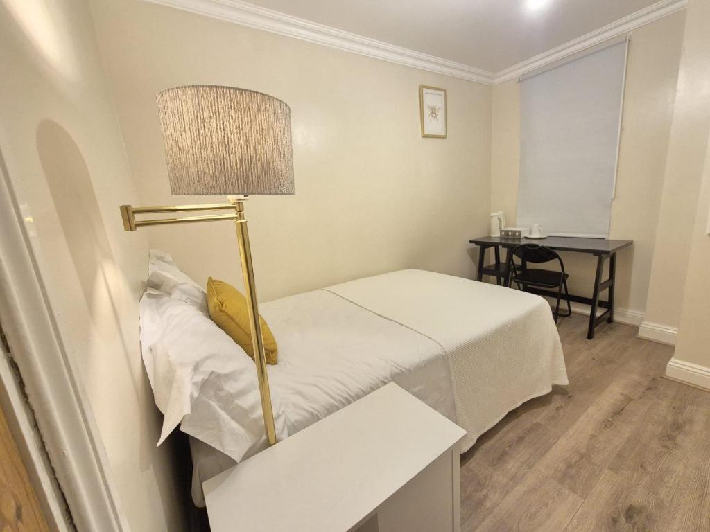 a small room with a bed and a lamp at Bethel House in Kennington