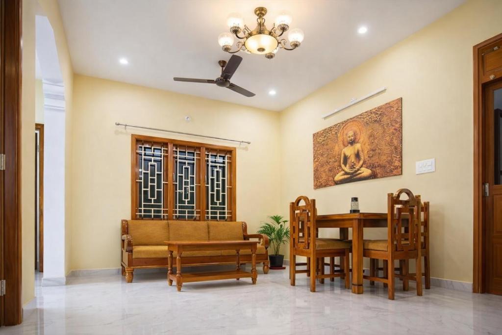 a dining room with a table and chairs and a ceiling at Sri Apartment Homestay 2BHK Pondicherry A2 in Pondicherry