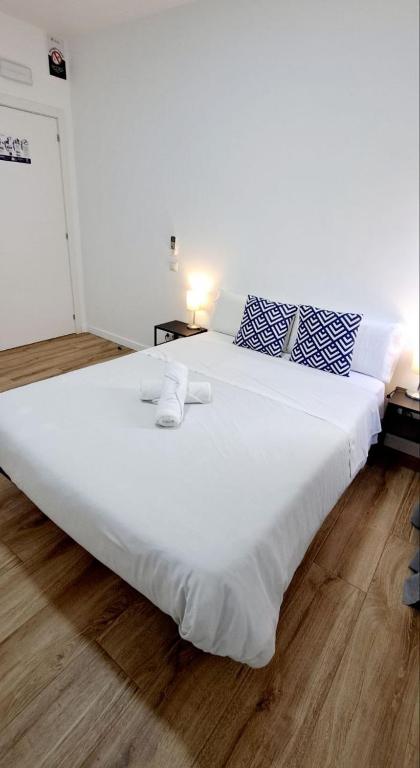 a large white bed with towels on it in a room at AYZ Joaquín Pol - Auto check-in property in Madrid