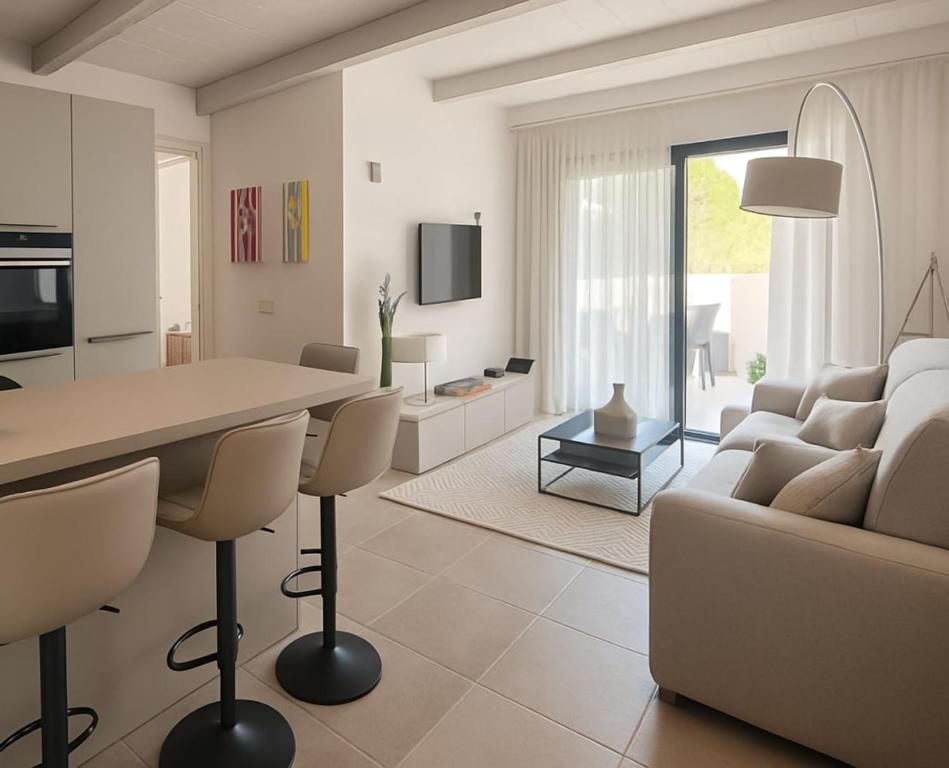 a white living room with a couch and a table at Casabaja in Baja Sardinia