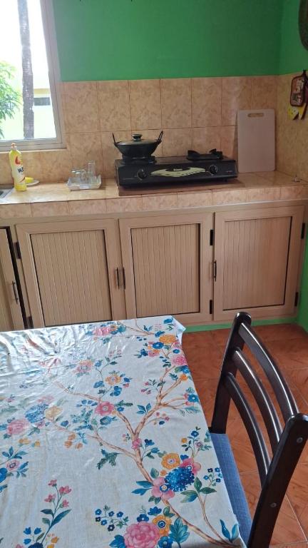 a kitchen with a table with a flower pattern on it at Chez Caze Maman in Crève Coeur