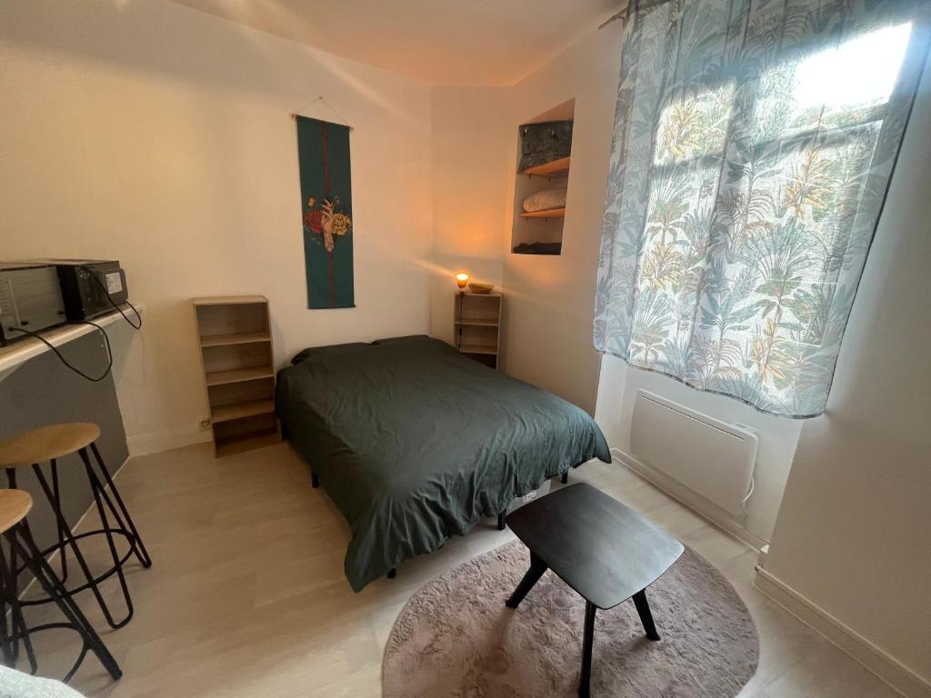 a small bedroom with a bed and a window at Studio meublé centre-ville Saint Junien in Saint-Junien