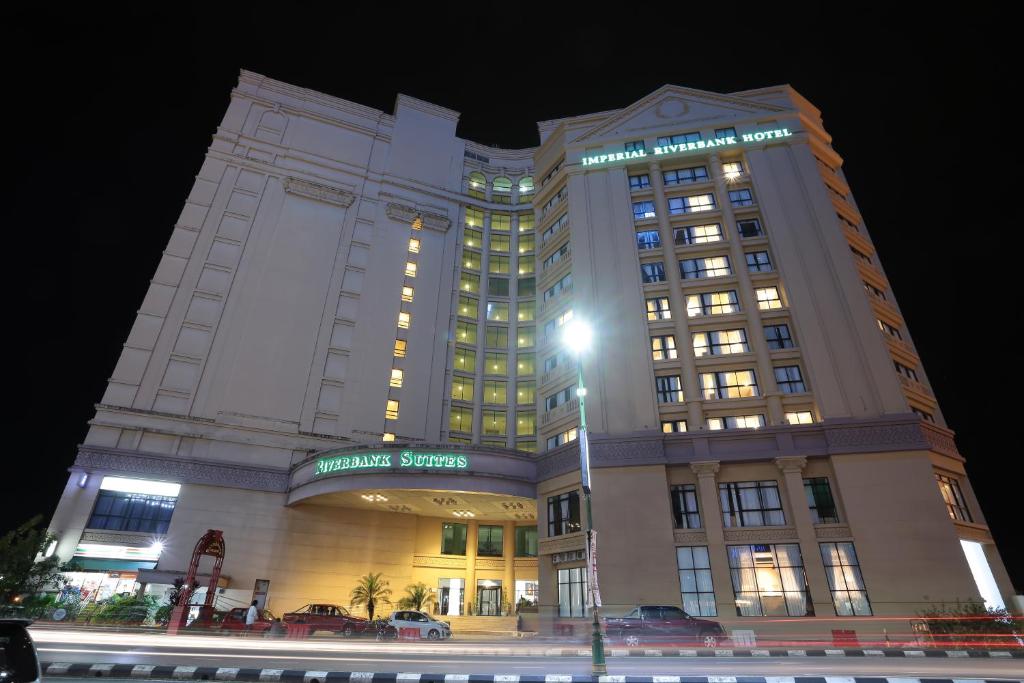 a large building with lights on it at night at Imperial Riverbank Hotel Kuching in Kuching