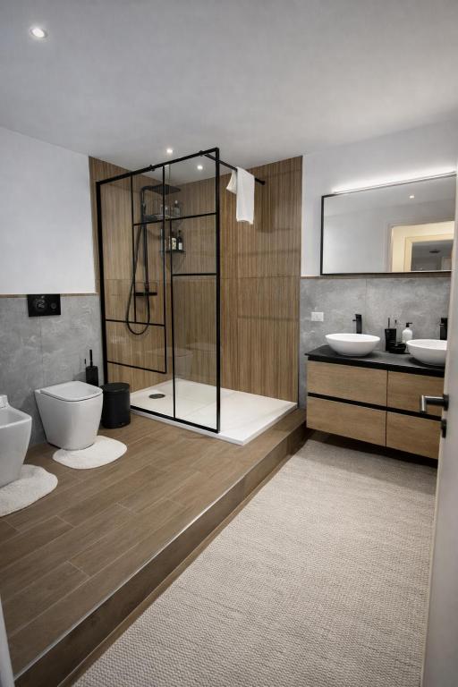 a bathroom with two sinks and a shower and a toilet at CASA NO-MA in centro storico in Marsala