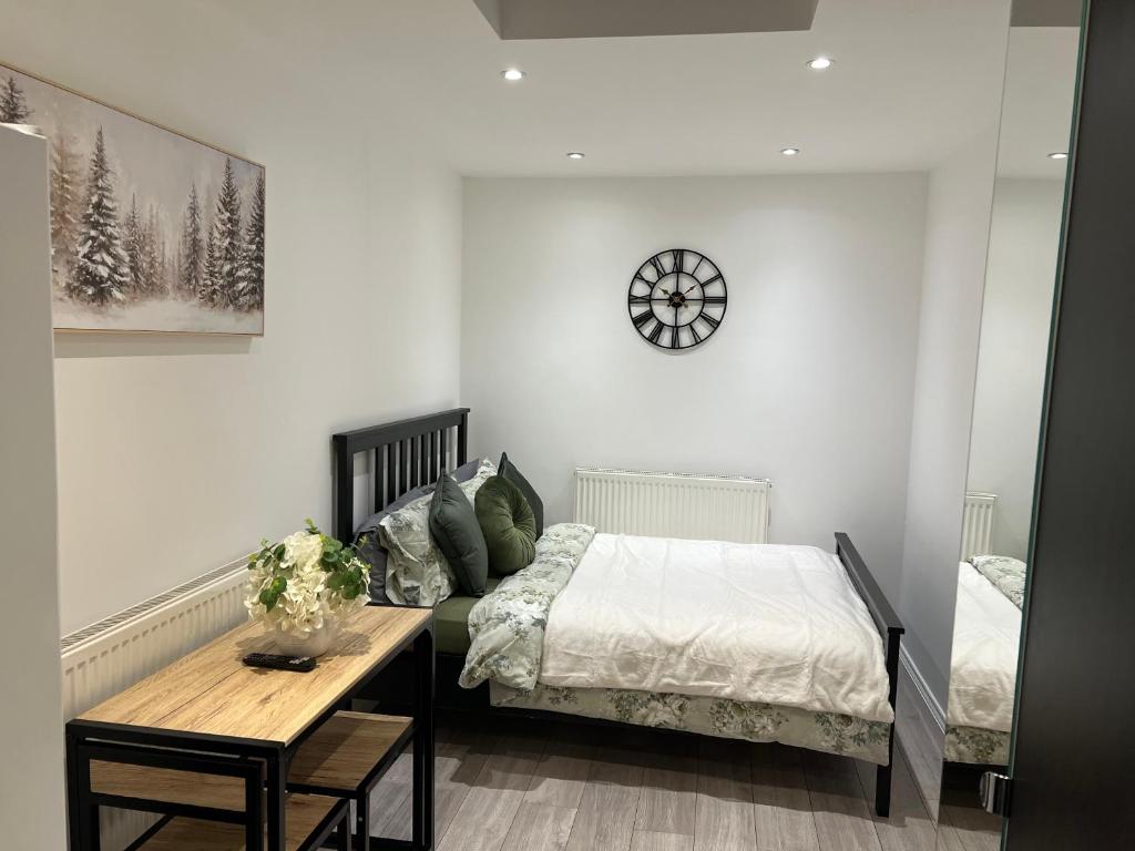 a bedroom with a bed and a table at Modern Studio flat with free parking in Langley Marish