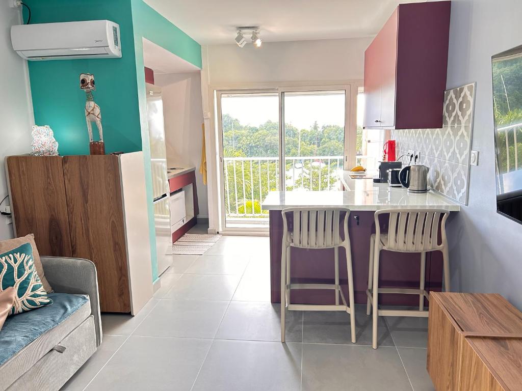 a kitchen with a table and chairs in a room at Rêve Marina studio tout confort avec citerne et piscine Gosier in Pointe-à-Pitre