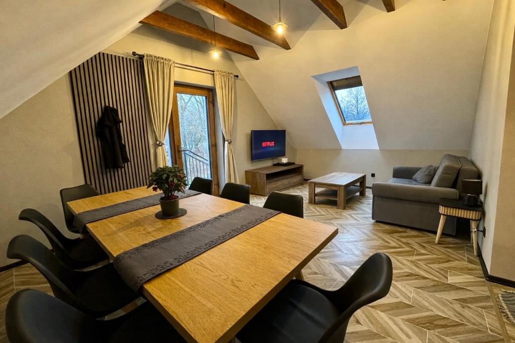 a living room with a wooden table and chairs at Na Fali Marszałka in Mielenko