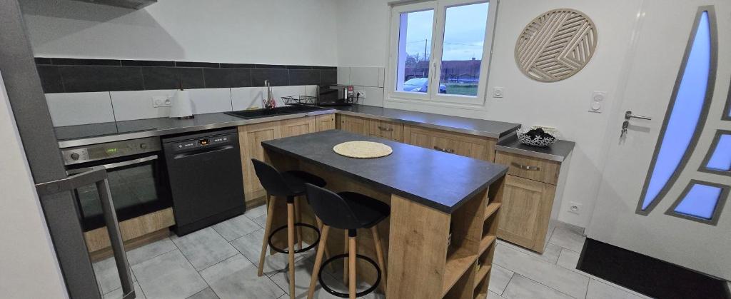 a kitchen with a island with a black counter top at Lauberge de Villeron in Savigny-en-Revermont