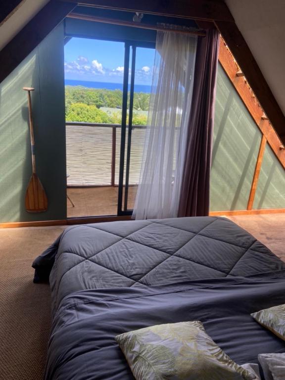 a bedroom with a bed and a large window at Hare Sunset Rapa Nui in Hanga Roa