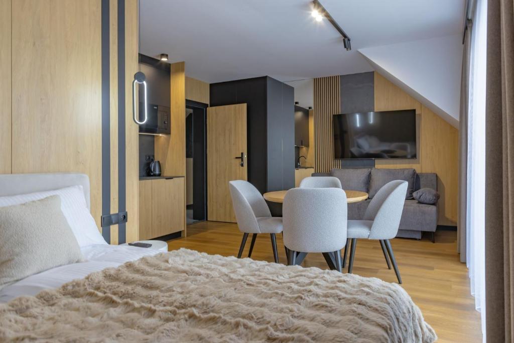 a bedroom with a bed and a table and chairs at Apart M in Krynica Zdrój