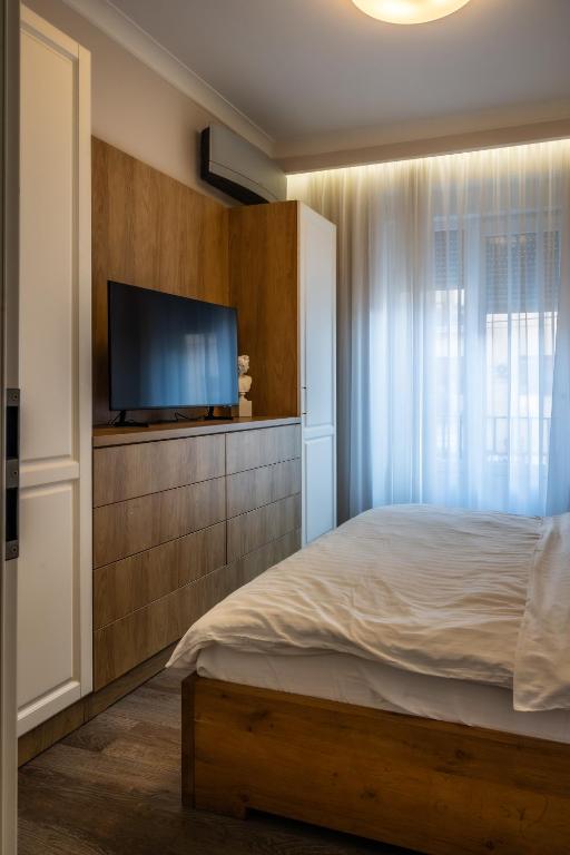 a bedroom with a bed and a flat screen tv at Apartament de lux central in Satu Mare