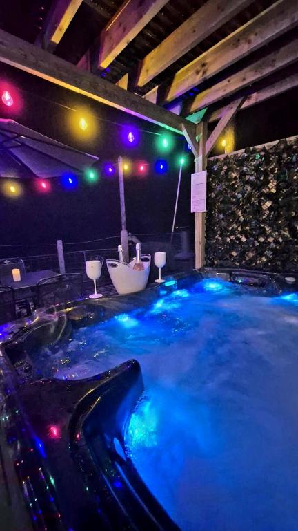 a large hot tub with blue lights in a room at Red Robin Cottage in Castlewellan