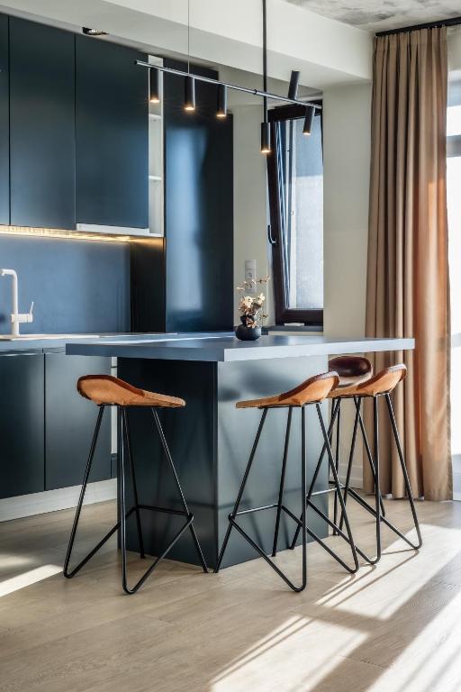 a kitchen with a blue island with two stools at Luxury Blue Apartment in Satu Mare