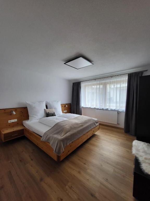 a bedroom with a large bed and a window at Ferienwohnung Pöll in Stanz bei Landeck