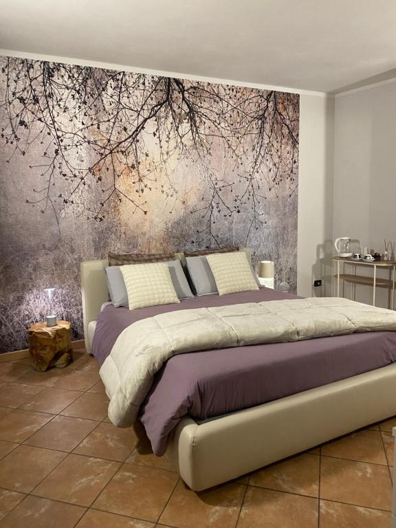 a bedroom with a large bed with a painting on the wall at Asfodelo rooms in Bra