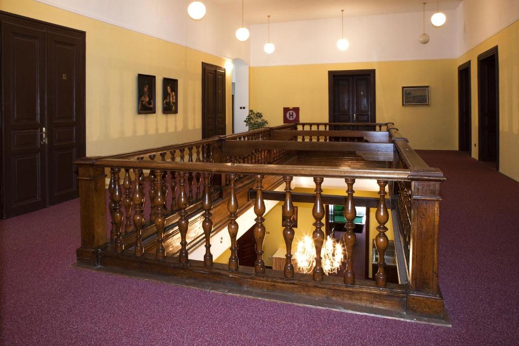 eine Treppe in einem Zimmer mit einem Holzgeländer in der Unterkunft Hotel Nobys in Nová Bystřice