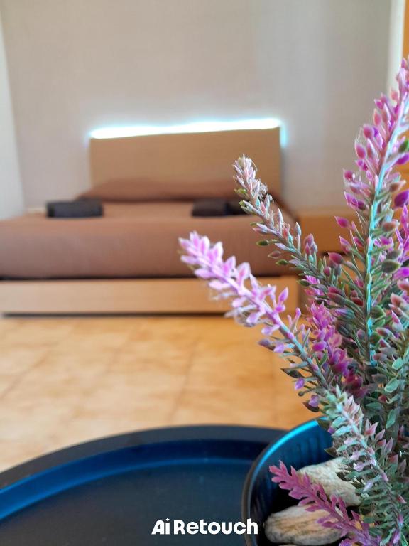 a vase with purple flowers in a room with a couch at Seven B&b in Casalmorano