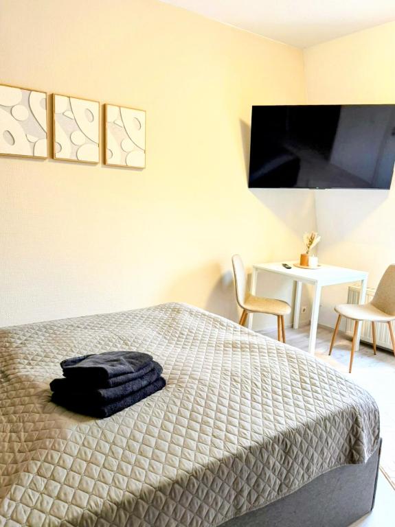 a bedroom with a bed and a table with chairs at SchaeBu! 7 Apartment Work and Travel am Altmarkt in Cottbus