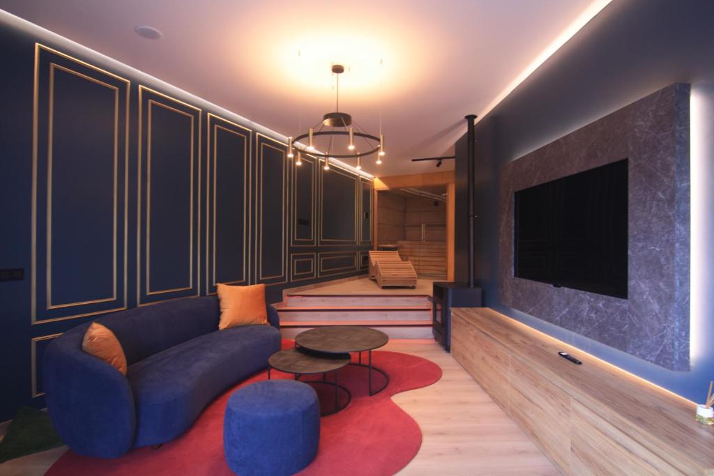 a living room with a blue couch and a tv at Casa dos Americanos - Suite Wellness in Briño