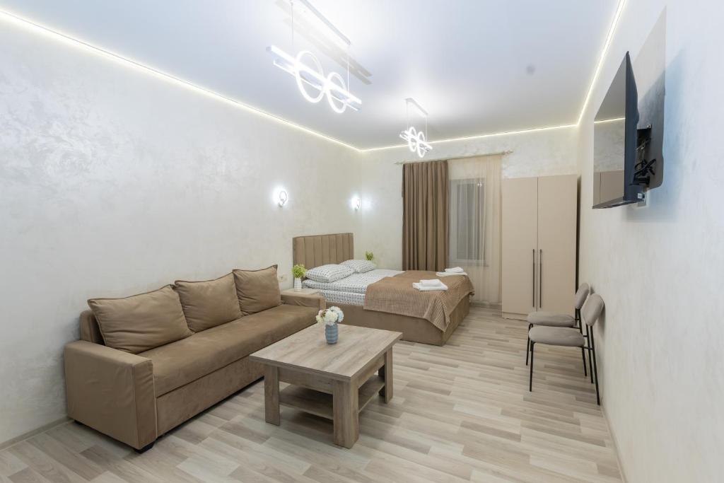 a living room with a couch and a bed at Myasnikyan Suites in Gyumri