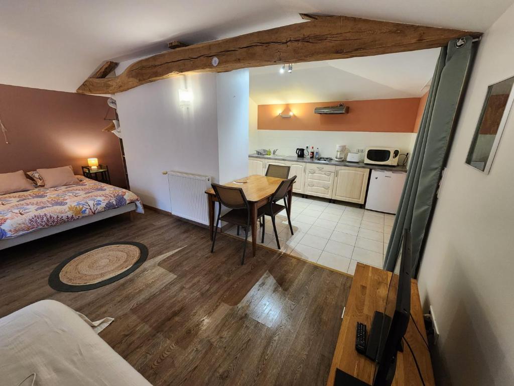 a room with a bed and a table and a kitchen at Studio du moulin de Montizeau in Saint-Maigrin