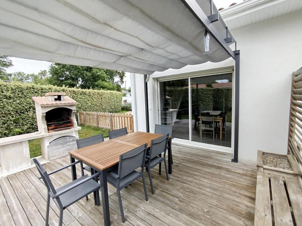 a deck with a table and chairs and a wood stove at Maisonnette Bassin d'Arcachon in Mios