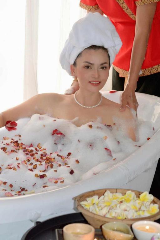 a woman in a bath tub with a woman in a towel at Ruen Rinna home stays in Surin