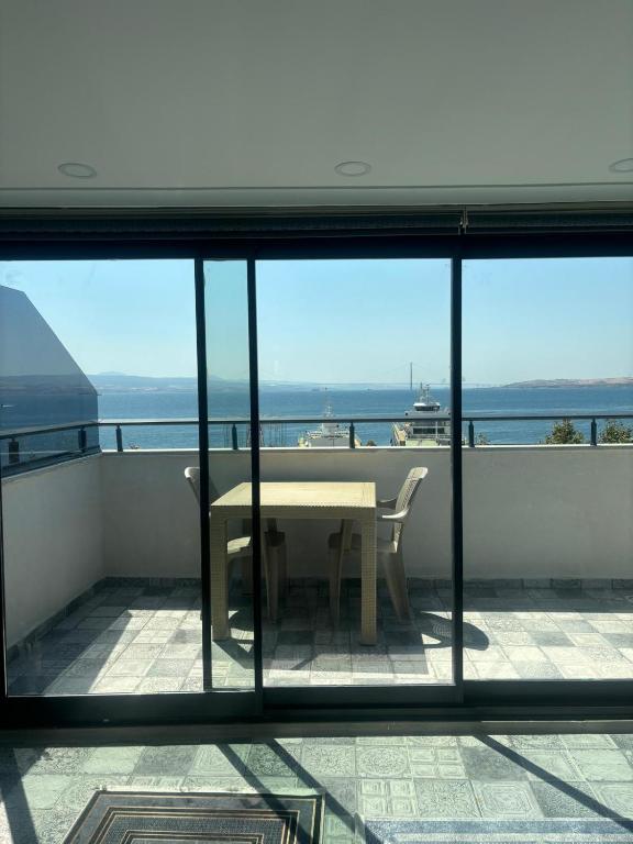 a balcony with a table and a view of the ocean at Sevez Homes in Gelibolu