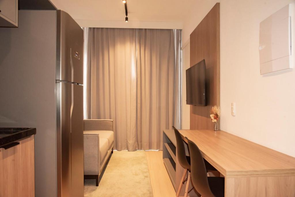a small kitchen with a table and a refrigerator at Essential comfort - Vila Mariana in São Paulo