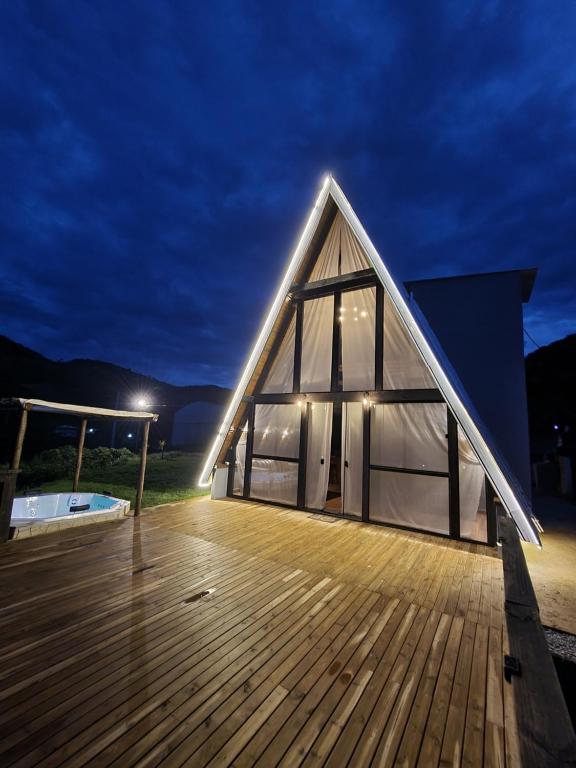 a large building with a wooden deck at night at Chalé do Campo in Sumidouro