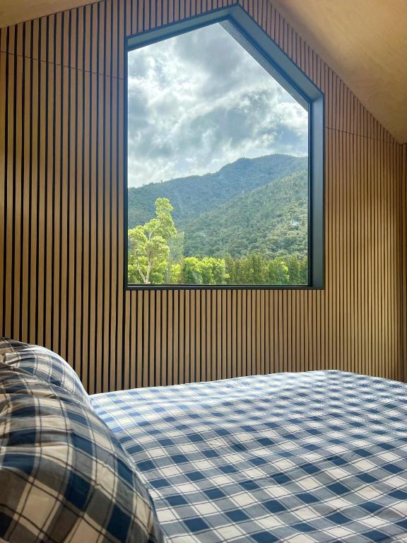 a bedroom with a window with a mountain view at Hikuai Hideaway in Hikuai