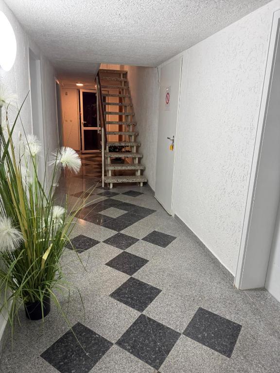a hallway with a staircase and a checkerboard floor at Nest-Unterkunft in Bad Überkingen