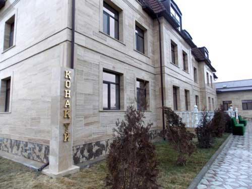 un bâtiment avec un panneau sur son côté dans l'établissement Hotel KREZ, à Kyzylorda
