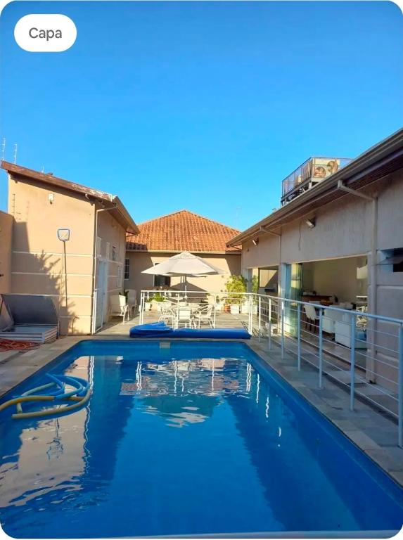 a swimming pool in a house with blue water at Pousada da Nona in Barretos