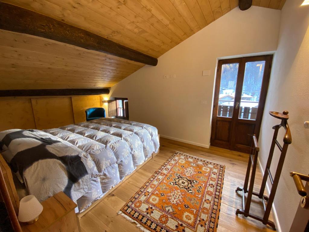 a bedroom with a bed and a rug and a window at Villa Vetto in Lanzada