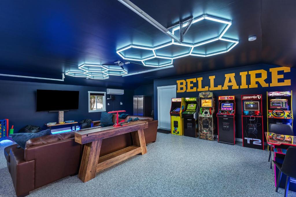 a room with arcade machines and a table and a television at Maple Street Retreat in Bellaire