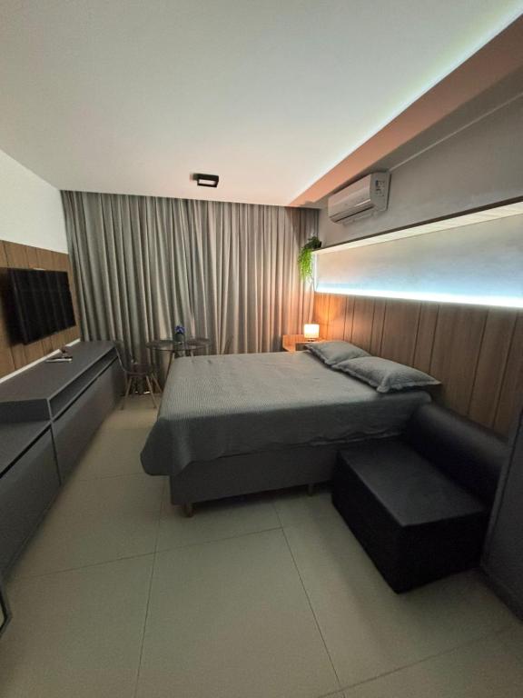 a bedroom with a bed and a bench in it at Flat Azzure 205 in Cabedelo
